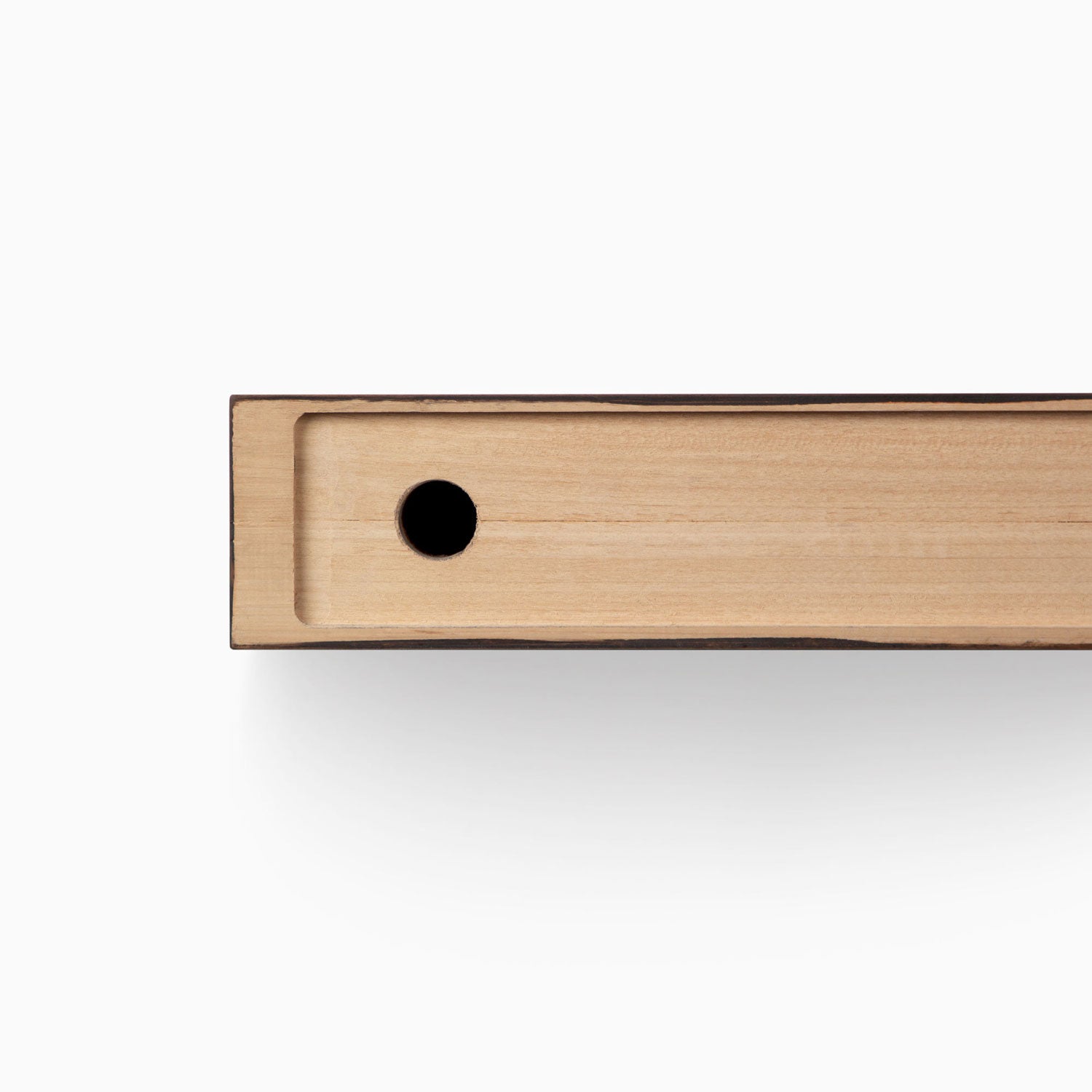 Close-up view of Glenn Nutmeg Floating Mantel edge showing wood grain and hole for floating shelf hardware installation.