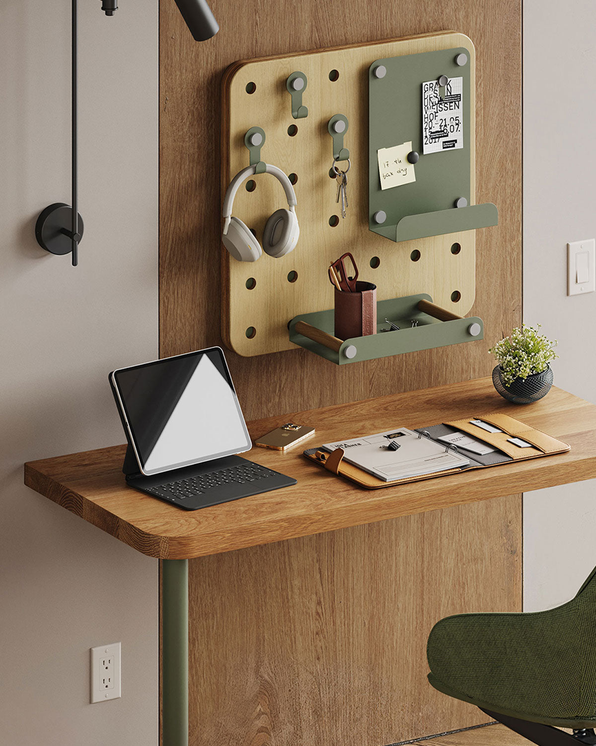 Home office with a wood wall organizer, green shelves, headphones, desk accessories, tablet, and a wood desk beneath it