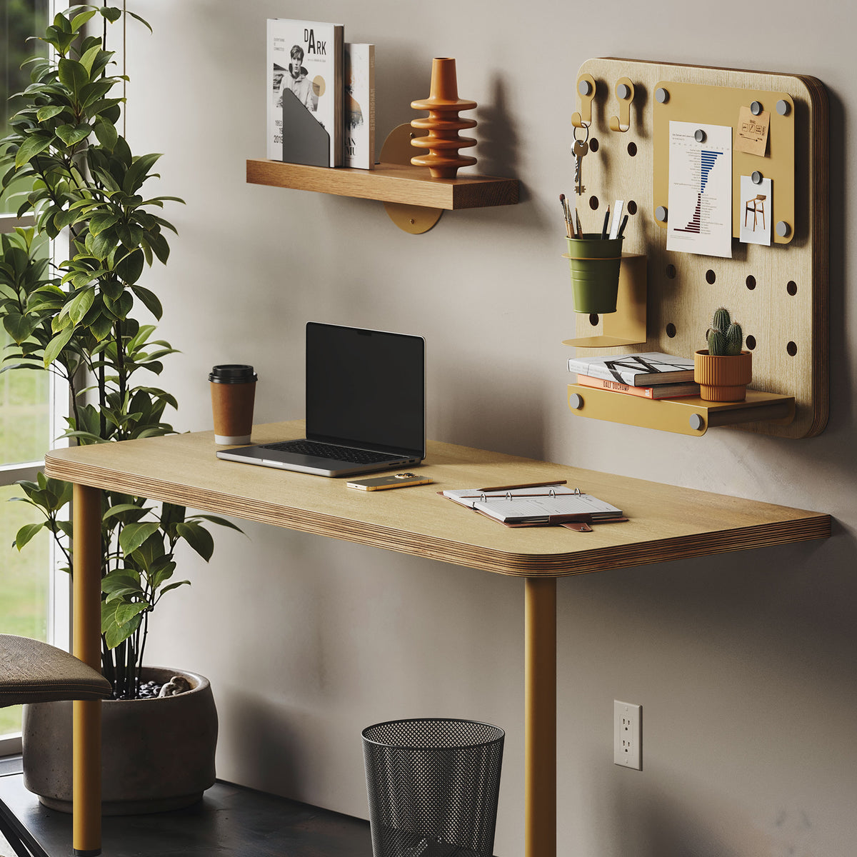 Arlo Desk (Baltic Birch) with a laptop, notebooks, coffee cup, wall shelf, and organized pegboard workspace