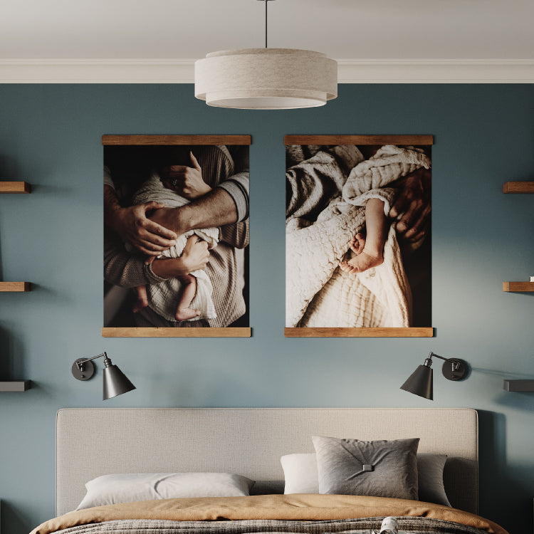 Modern bedroom with teal walls featuring two framed family photos above a beige upholstered bed and wall-mounted reading lamps