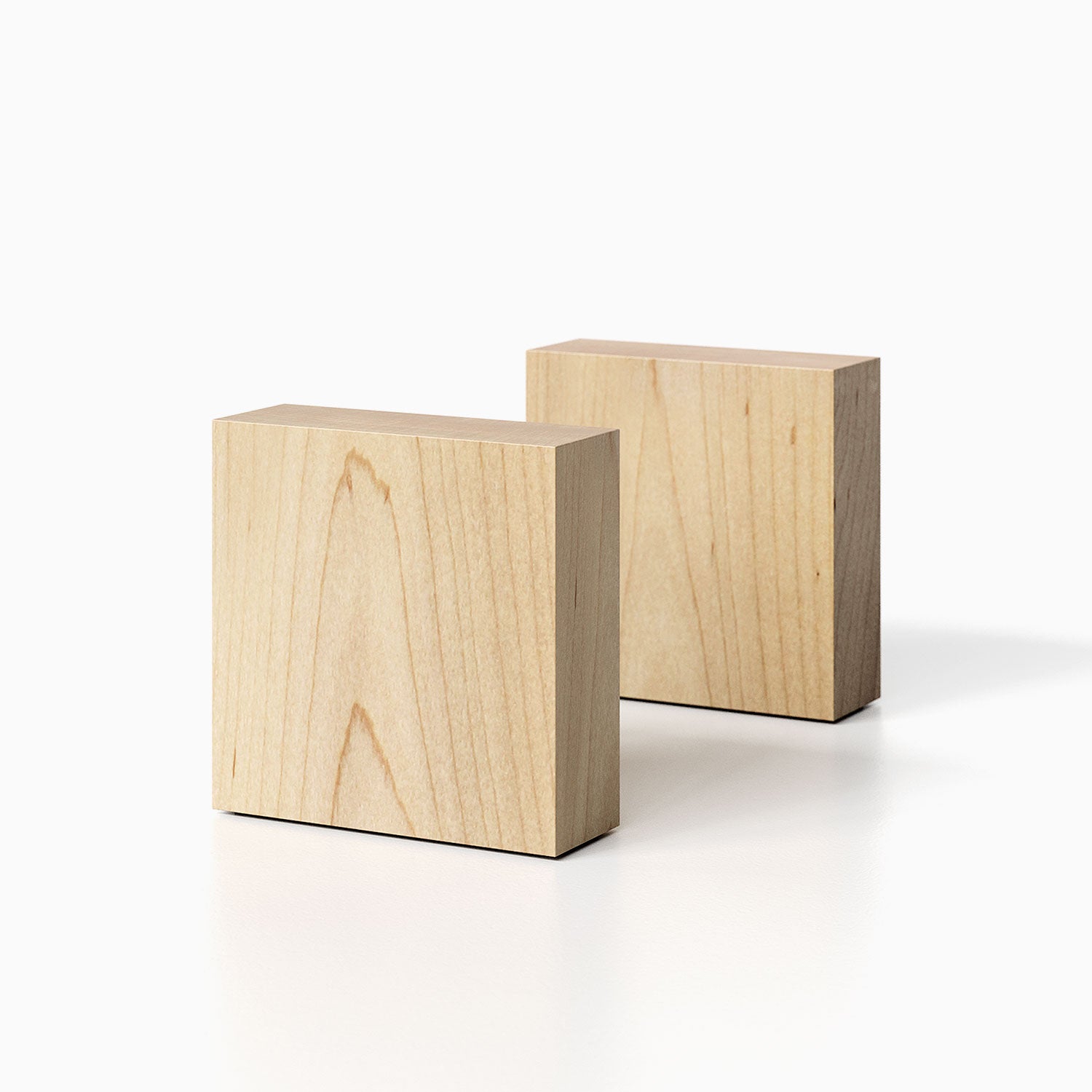 The Maggie Square Product (maple finish) pictured against a white background. Two bookends positioned in the center, one slightly off center, in front of the other.