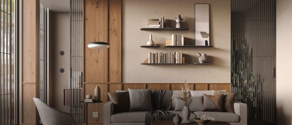 Modern living room with wood wall panels a gray sofa and three dark floating shelves displaying books decor and framed art