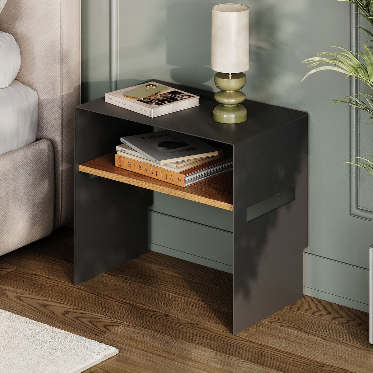 Tuck In Nightstand in black with an open wood shelf holding books beside a bed and lamp for compact bedroom storage