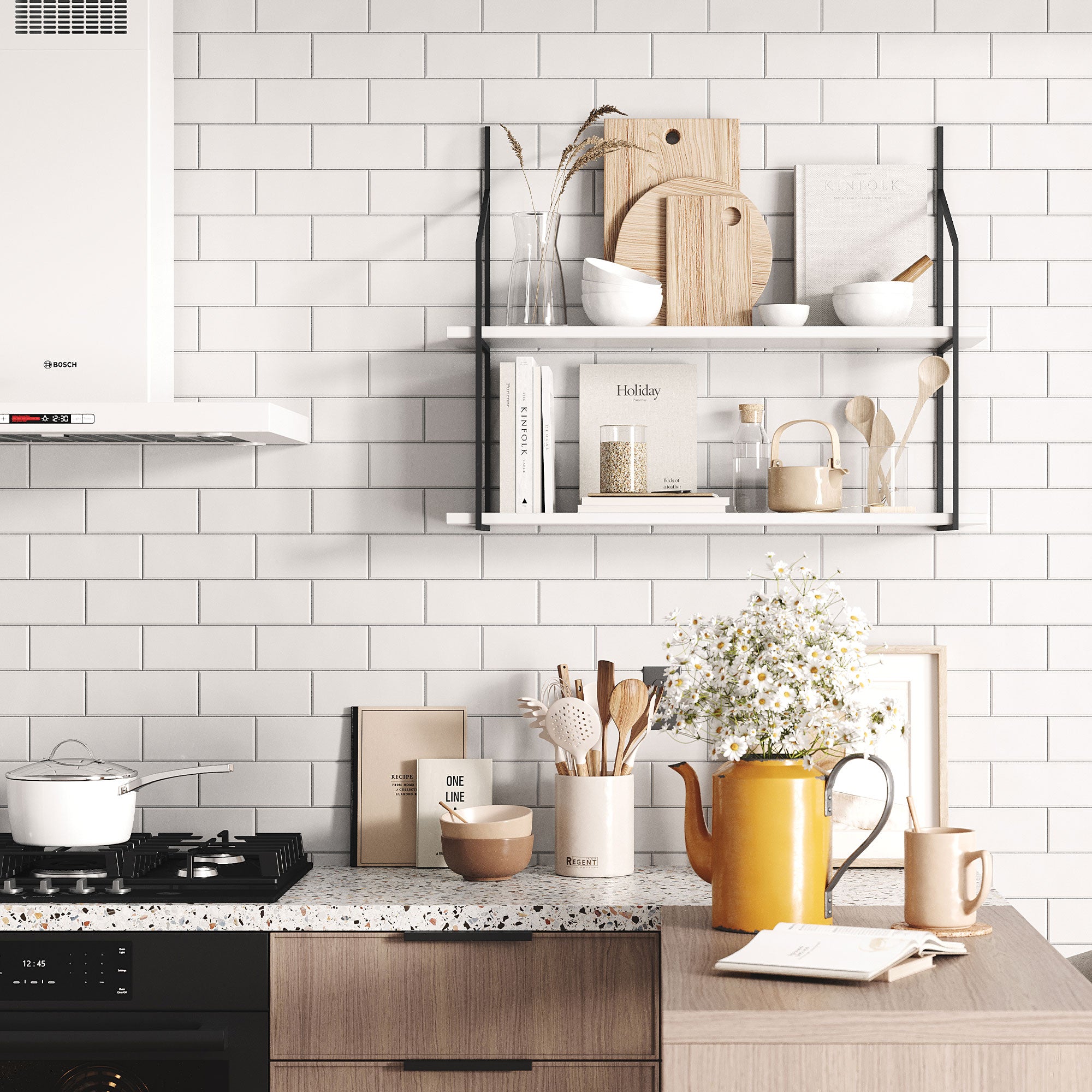 Modern kitchen with white subway tile backsplash featuring the Shelfology Verne 2-Tiered Wall Shelf in matte black and white, styled with neutral cookbooks, wood cutting boards, ceramic bowls, and minimalist decor.