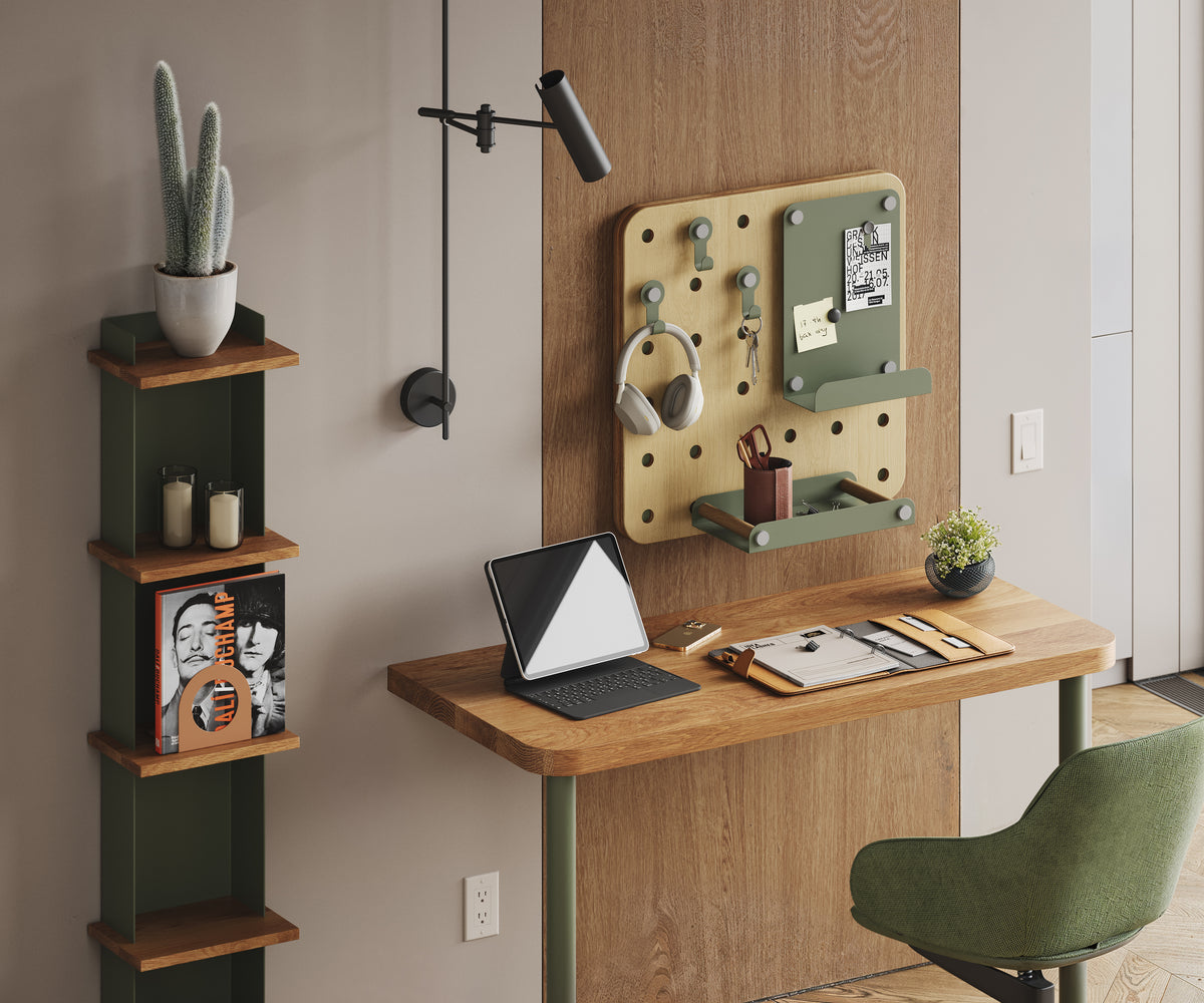 Compact wall mounted workspace with a wood desk vertical shelves pegboard organizer laptop task lamp and green chair