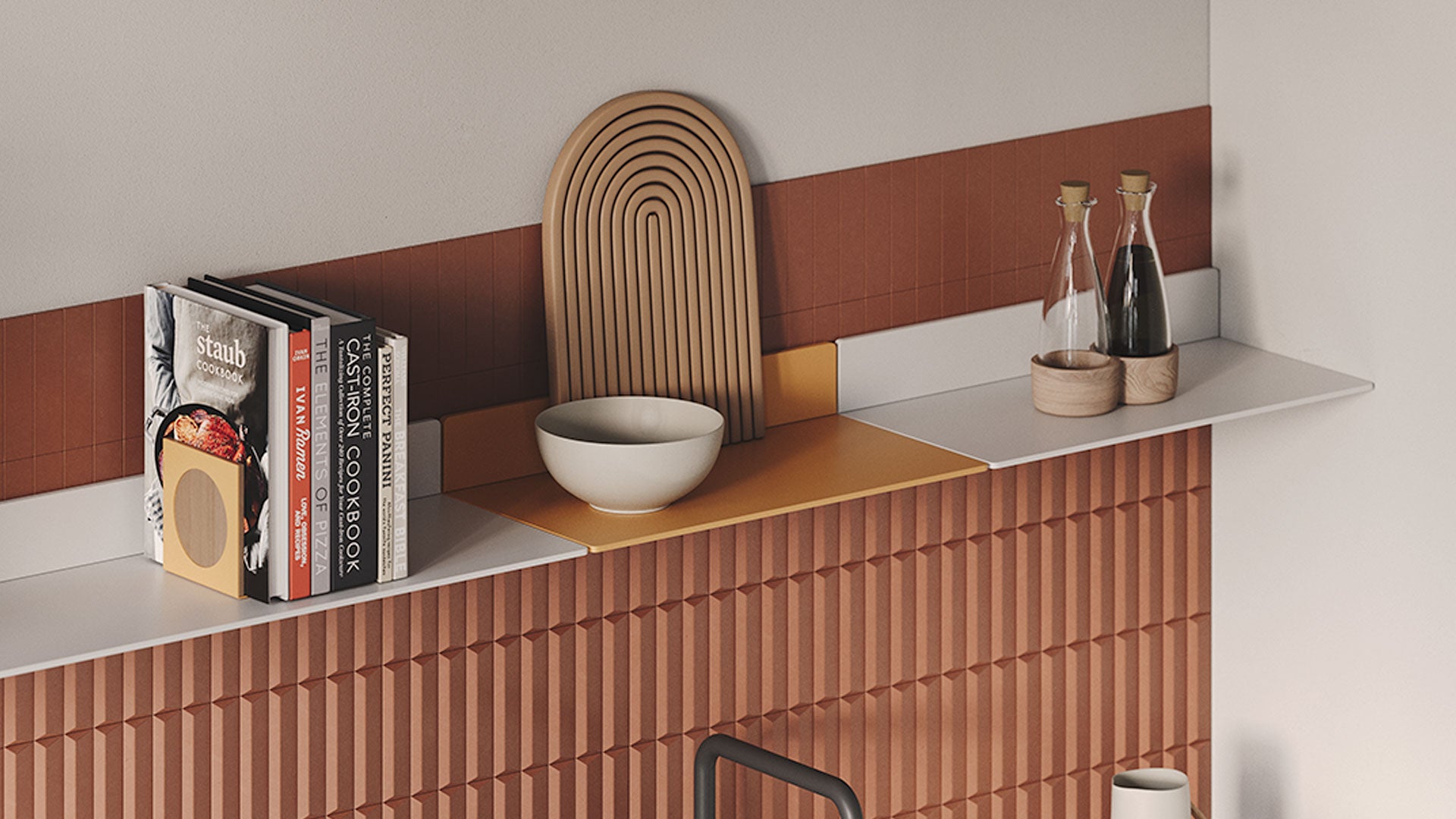 Modern white floating shelf holds cookbooks, ceramic bowl, decorative arch, and glass bottles against a textured rust wall.
