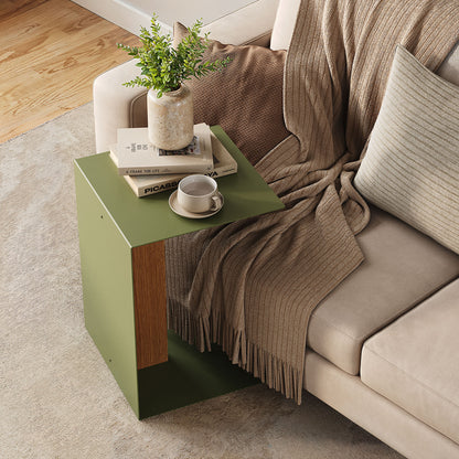 Baxter Side Table in olive green with a wood accent beside a sofa styled with books a plant and coffee cup
