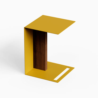 Baxter Side Table in gold metal with a dark wood accent panel and open C shaped design for versatile bedside or sofa use