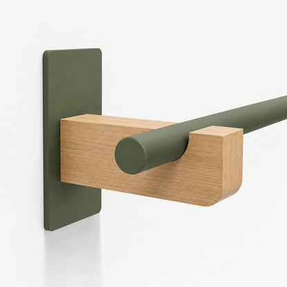 Close-up of a Draper Curtain Rod System featuring a minimalist olive green metal rod supported by a solid hardwood bracket mounted on a white wall.
