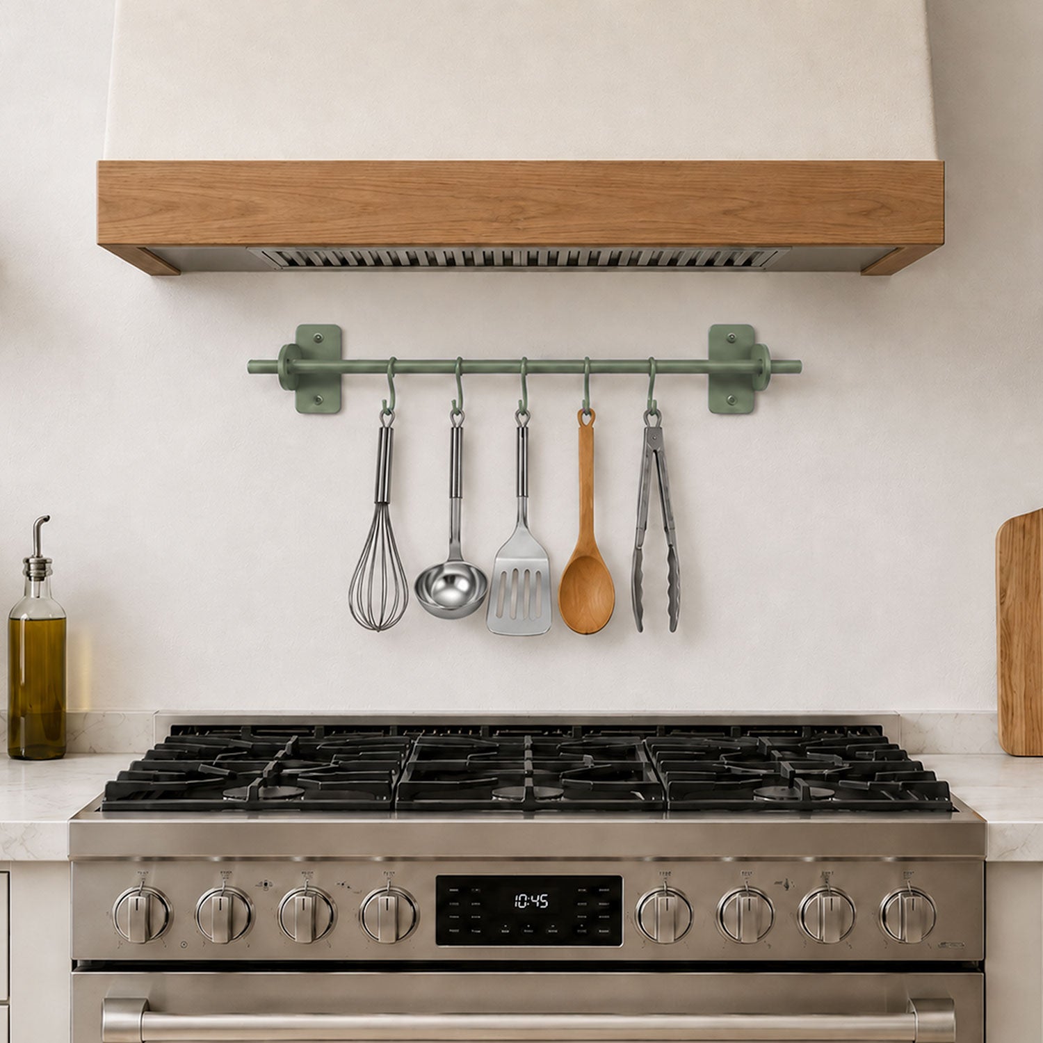 Etta Utensil Rack mounted on a kitchen wall above a stainless steel stove, holding metal and wooden cooking utensils in a minimalist, functional space.