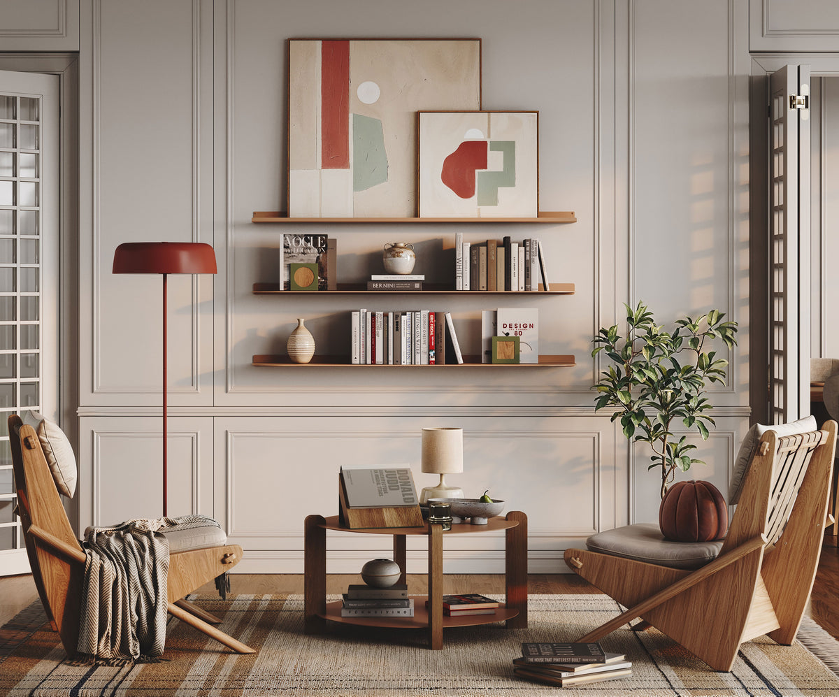 Living room with wood wall shelves displaying books and decor beside framed art chairs a plant and a low coffee table