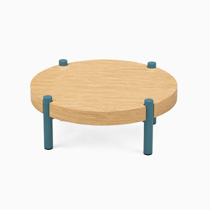 Fern Plant Stand (White Oak) with a round solid hardwood top supported by four sturdy blue metal legs, minimalist and functional design ideal for display and organization.
