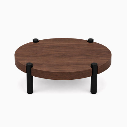 Fern Plant Stand (Walnut) featuring a minimalist round walnut wood platform with four sturdy black metal legs, perfect for displaying plants and decor.