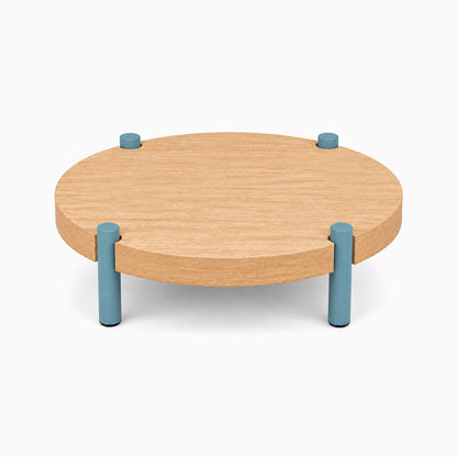 Fern Plant Stand (White Oak) with a round solid hardwood top supported by four short steel legs in a muted blue finish for minimalist display and organization.