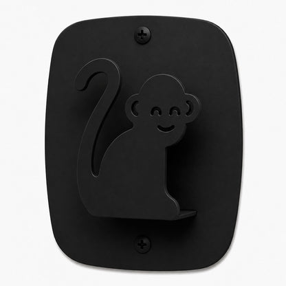 Kiddo Hooks in black metal shaped like a smiling monkey mounted on a flat wall plate, designed for functional wall organization.
