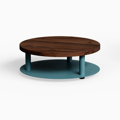 Ledger Coffee Table with round solid hardwood walnut top and sturdy teal steel base, blending mixed-material design for modern living spaces.