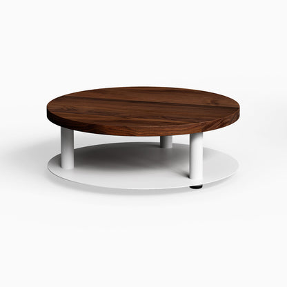 Ledger Coffee Table featuring a minimalist round walnut wood top balanced on a sturdy white metal base for modern living spaces.