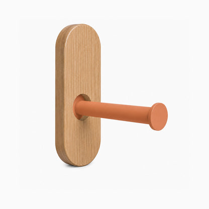 Lou Toilet Paper Holder featuring a minimalist wood backplate and a rust-resistant matte clay-colored metal arm for modern bathroom organization.