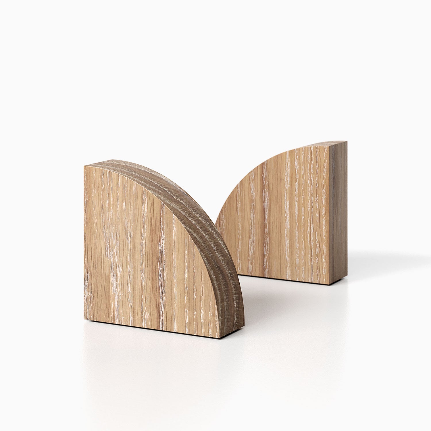 The Maggie Radius Product (White oak glazed finish) pictured against a white background. Two bookends positioned in the center, one slightly off center, in front of the other.