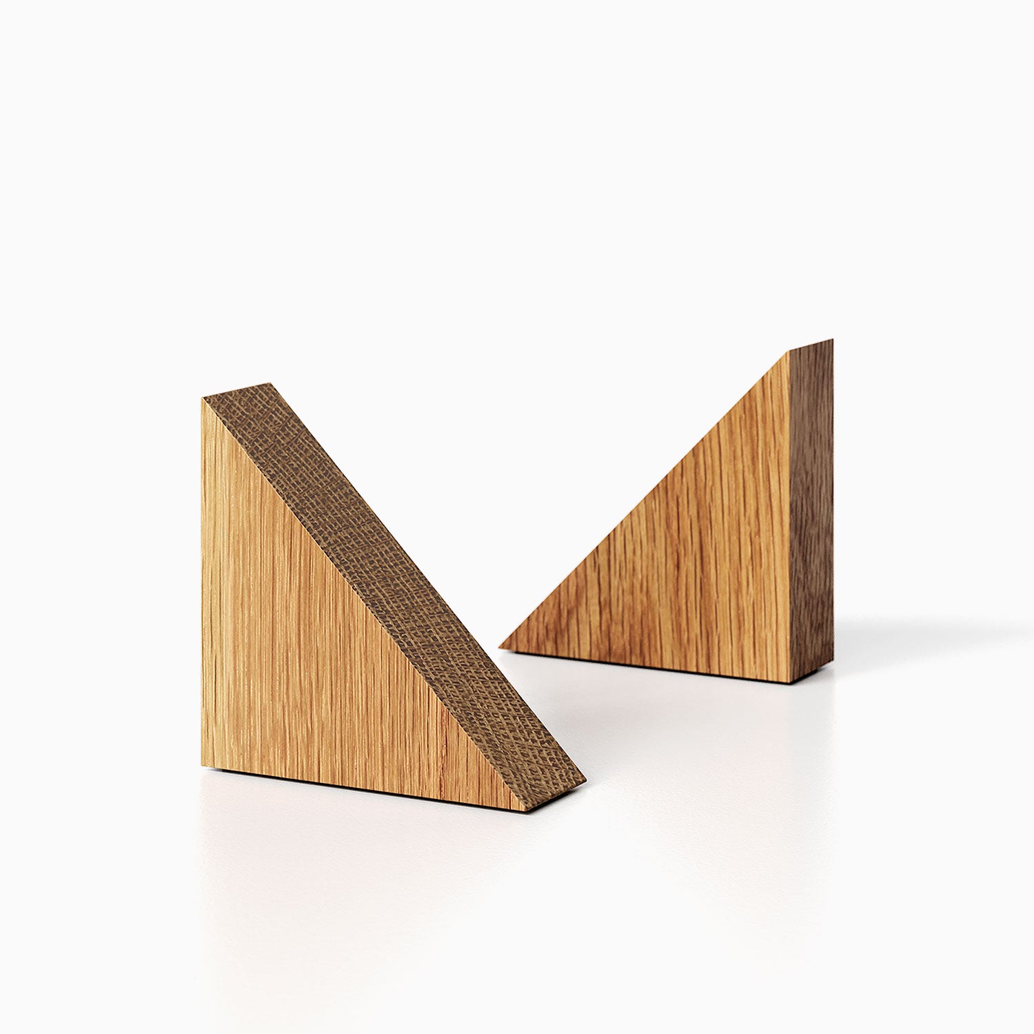 The Maggie triangle Product (white oak finish) pictured against a white background. Two bookends positioned in the center, one slightly off center, in front of the other.

