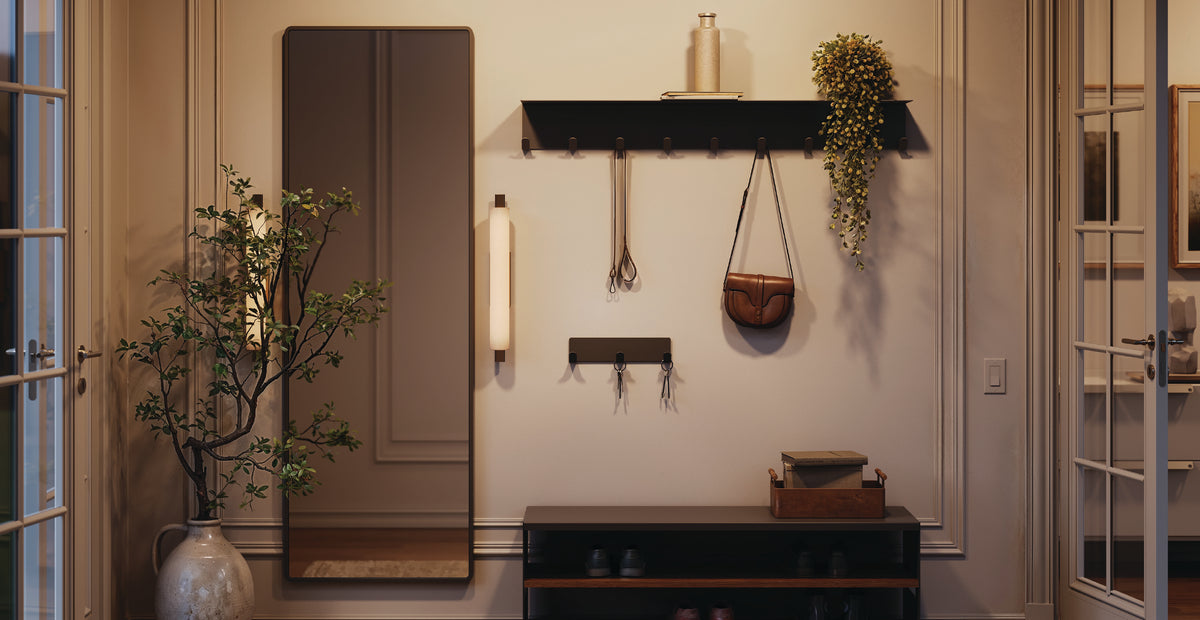 Warm entryway featuring black wall shelves, hanging planters, hooks, framed panels, a console cabinet, and indoor greenery
