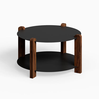 Otis Round Coffee Table featuring a minimalist design with black metal surfaces and solid walnut wood legs, ideal for modern living spaces.