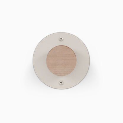 Runda Coat Rack 1 round wall mounted coat rack with a light wood center and neutral circular faceplate