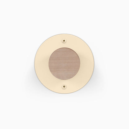 Runda Coat Rack 1 with a round cream finish wood center and two visible mounting screws for wall organization