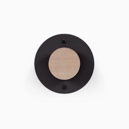 Runda Coat Rack 1 black circular wall mounted coat rack with a natural wood peg and two visible mounting screws
