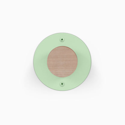 Runda Coat Rack 1 with a round green wall plate wood center and two visible mounting screws for minimalist entryway organization