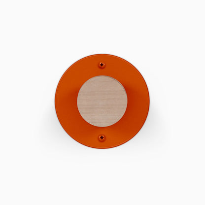 Runda Coat Rack 1 orange circular wall hook with a light wood center and two visible mounting screws