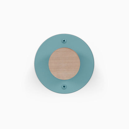 Runda Coat Rack 1 round teal wall hook with a natural wood center and two visible mounting screws for organized entryways