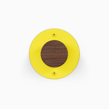 Runda Coat Rack 1 yellow circular wall hook with a walnut wood center and visible mounting screws for organized wall storage