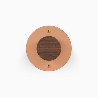 Runda Coat Rack 1 round copper tone wall hook with a dark wood center and two visible mounting screws
