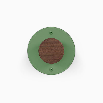Runda Coat Rack 1 round green wall mounted coat rack with a contrasting wood center and two visible mounting screws