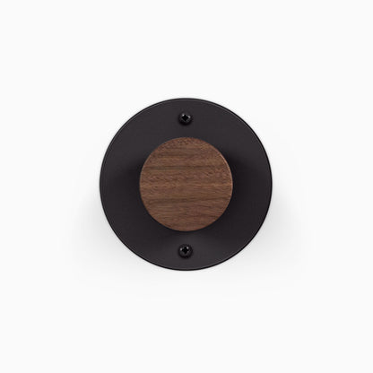 Runda Coat Rack 1 round black wall mounted coat hook with a walnut wood accent and visible mounting screws
