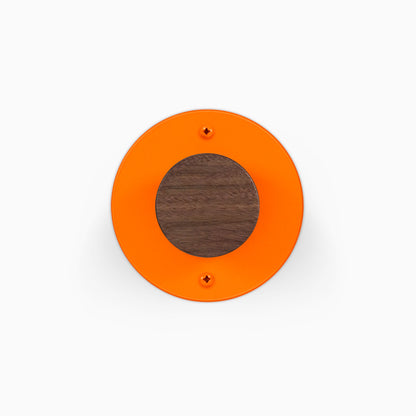 Runda Coat Rack 1 orange circular wall mounted rack with a dark wood center and two visible mounting screws
