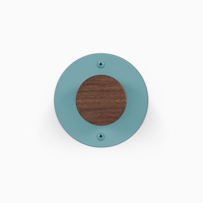 Runda Coat Rack 1 round teal wall mounted coat rack with a wood center and two visible mounting screws