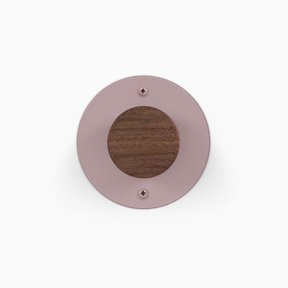 Runda Coat Rack 1 round mauve wall mounted coat rack with a contrasting dark wood center and visible mounting screws
