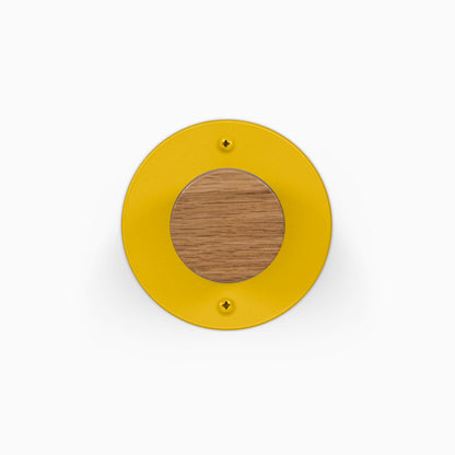 Runda Coat Rack 1 yellow circular wall hook with a round wood center and two visible mounting screws