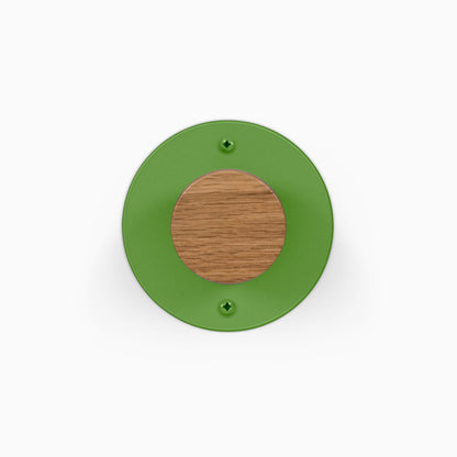 Runda Coat Rack 1 green circular wall mounted rack with a round wood center and two visible mounting screws