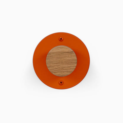 Runda Coat Rack 1 orange round wall hook with a wood center and two visible mounting screws