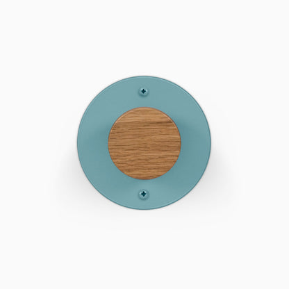 Runda Coat Rack 1 round teal wall mounted coat rack with a natural wood center and two visible mounting screws