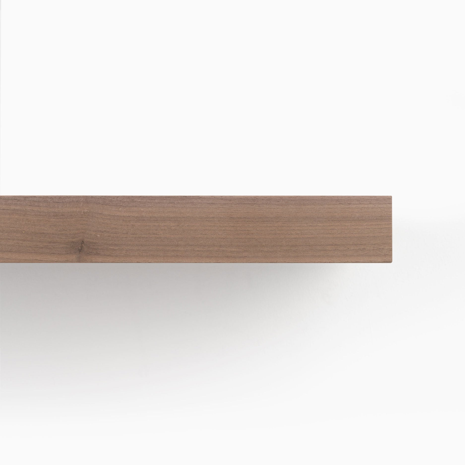 Close-up view of the edge of an Unfinished Walnut Wood Slab showcasing its natural wood grain and smooth texture.