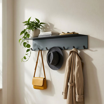 Splendid Shelf + Coat Hooks in matte black metal with five hooks holding a tan bag, gray hat, and beige coat beneath a shelf displaying a potted plant and books