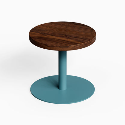 Spot On Side Table with round dark wood top and teal metal pedestal base against a white background