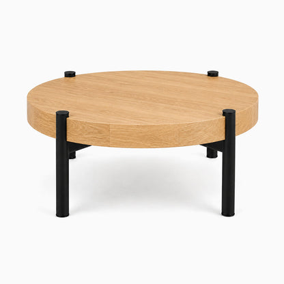Stay Coffee Table with a round solid hardwood top and black steel legs, showcasing a minimalist design perfect for organized living spaces.
