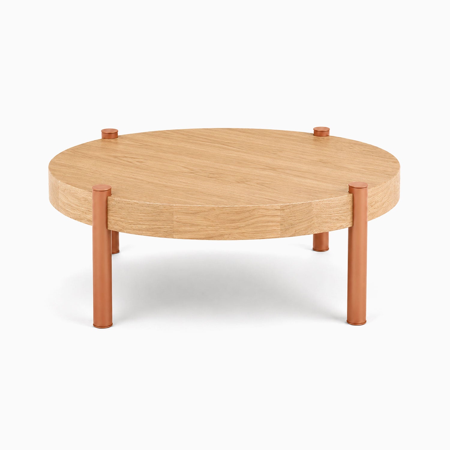 Stay Coffee Table featuring a minimalist round solid hardwood top with durable rust-resistant steel legs in a warm earthy tone, designed for functional living.