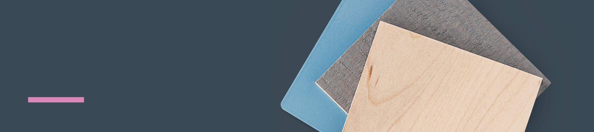 Three layered sample swatches in natural wood, muted blue, and textured gray resting on a dark blue background with a small pink horizontal accent bar.