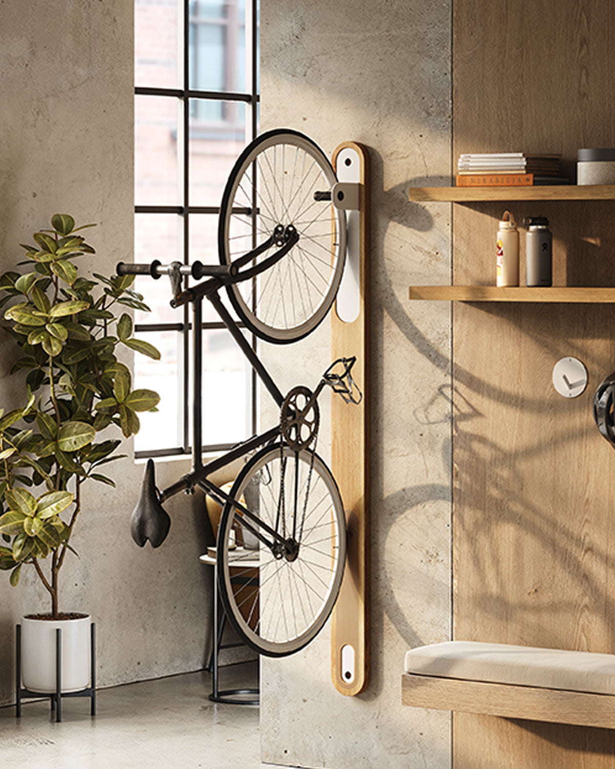 Vertical wood bike rack holding black bicycle on concrete wall near wood floating shelves and potted plant in bright room